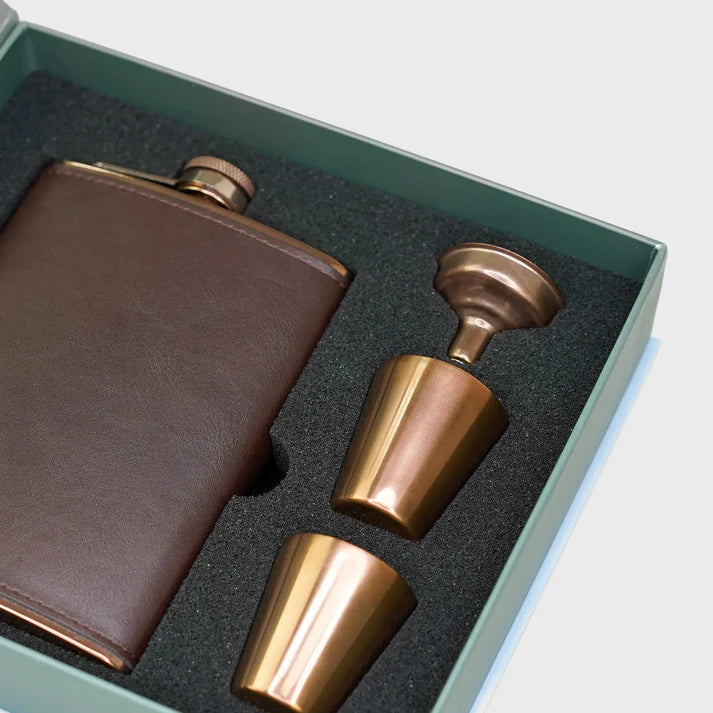 Brown leather flask and two bronze cups in a green box.